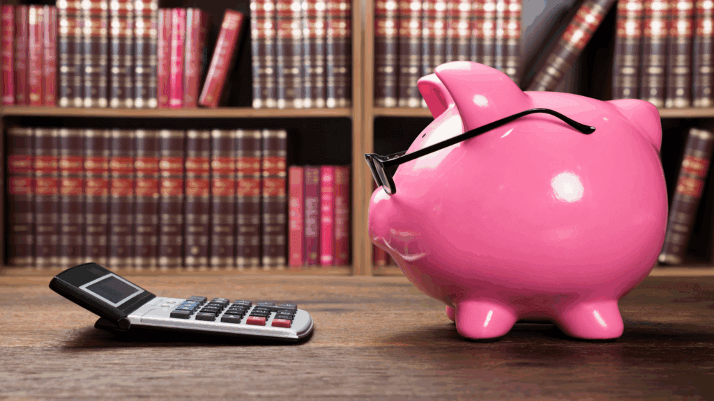Pink piggy bank and calculator symbolizing budgeting before college