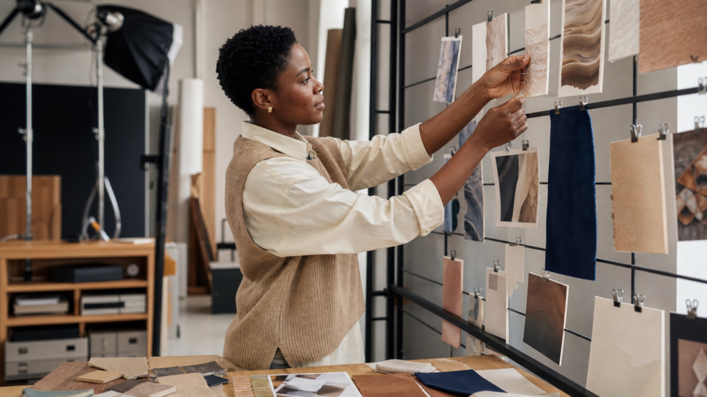 An adult volunteer organizing an abstract visual-consistency board using color, layout, and photography samples without logos or readable copy.